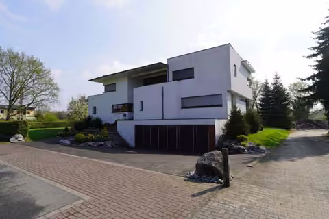 Zwangsversteigerung Zweifamilienhaus in Bergkamen, Overberge – Südwestansicht des freistehenden Zweifamilienhauses mit Zufahrt und Garagen.