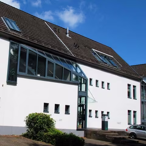 Zwangsversteigerung Wohn-/Geschäftshaus in Nümbrecht – Straßenansicht des Wohn- und Teileigentums Haus 1 mit verglastem Treppenhaus