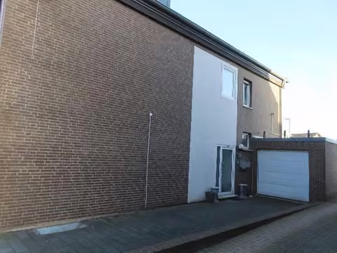 Zwangsversteigerung Büro in Erkelenz, Gerderath – Seitliche Ansicht des Gebäudes und Zufahrtsbereich.