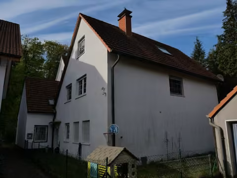 Zwangsversteigerung Doppelhaushälfte in Halle (Westf.), Hörste – Außenansicht der Doppelhaushälfte mit Hauseingang und Gartenbereich.