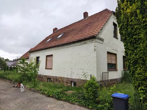 Zwangsversteigerung Einfamilienhaus in Lübbecke – Seitenansicht des Wohngebäudes und Zufahrtsbereich.