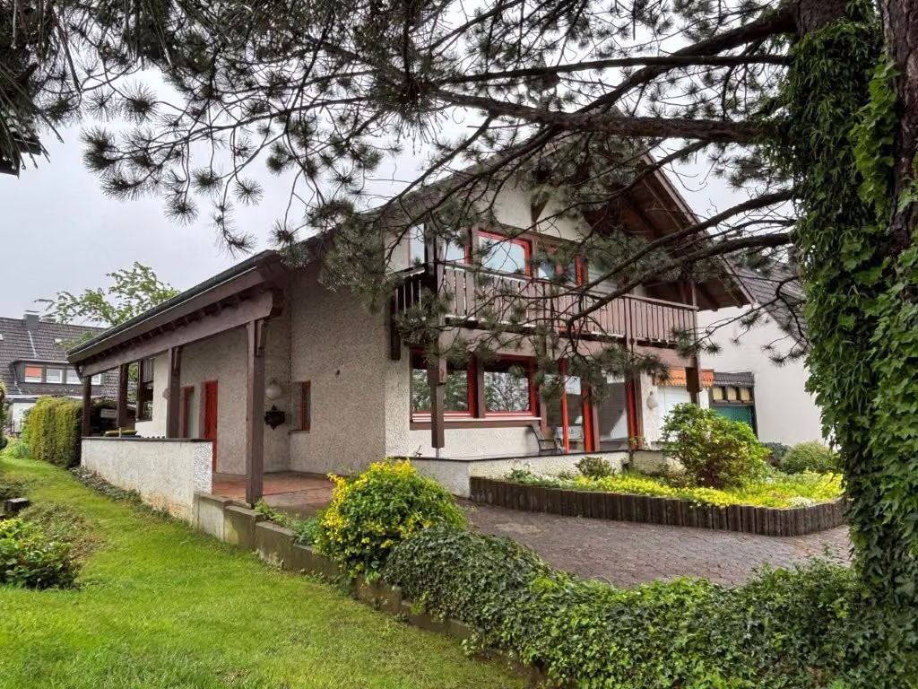 Zwangsversteigerung Einfamilienhaus in Iserlohn, Griesenbrauck – Vorder- und Seitenansicht des Gebäudes mit Vorgarten und Zufahrtsbereich.