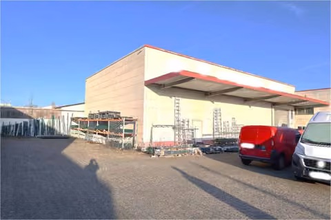 Zwangsversteigerung Grundstück in Hamm, Wiescherhöfen – Straßen- und Frontansicht des Hallengebäudes mit befestigtem Vorplatz