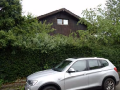 Zwangsversteigerung Einfamilienhaus in Gauting – Nordwestseite des Wohngebäudes mit Gartenbereich.