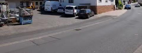 Zwangsversteigerung Wohn-/Geschäftshaus in Gersfeld, Hettenhausen – Hauptansicht mit Hofzufahrt und Garagengebäude.