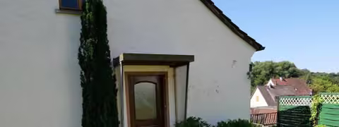 Zwangsversteigerung Wohn-/Geschäftshaus in Gersfeld, Hettenhausen – Separater Eingang der Einliegerwohnung im Anbau.