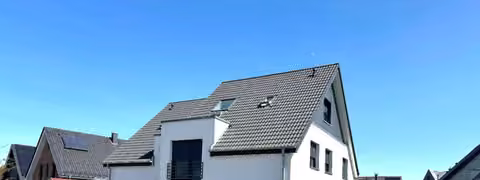 Zwangsversteigerung Doppelhaushälfte in Everswinkel – Außenansicht des Zweifamilienhauses von Südwesten mit Zufahrt und Carport.