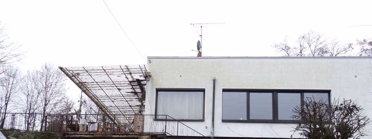 Zwangsversteigerung Einfamilienhaus in Motten – Nord-Ost-Ansicht des Wohnhauses mit Terrassenüberbau und Garagenzufahrt.