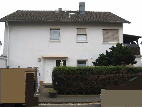 Zwangsversteigerung Mehrfamilienhaus in Büdingen – Vorderansicht mit Hauseingangsbereich und Vorgarten.