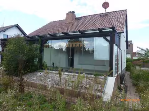 Zwangsversteigerung Einfamilienhaus in Weiterstadt – Gartenseitige Ansicht von Süden mit verglastem Wintergartenanbau.