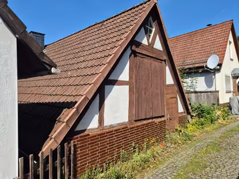Zwangsversteigerung Einfamilienhaus in Biedenkopf – Rückansicht des Dachbereichs mit ebenerdiger Luke zur oberen Straße Nonnenberg.